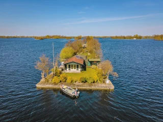 Een eiland op het water met een sloep