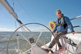 Man bestuurd een zeilboot