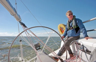 Man bestuurd een zeilboot
