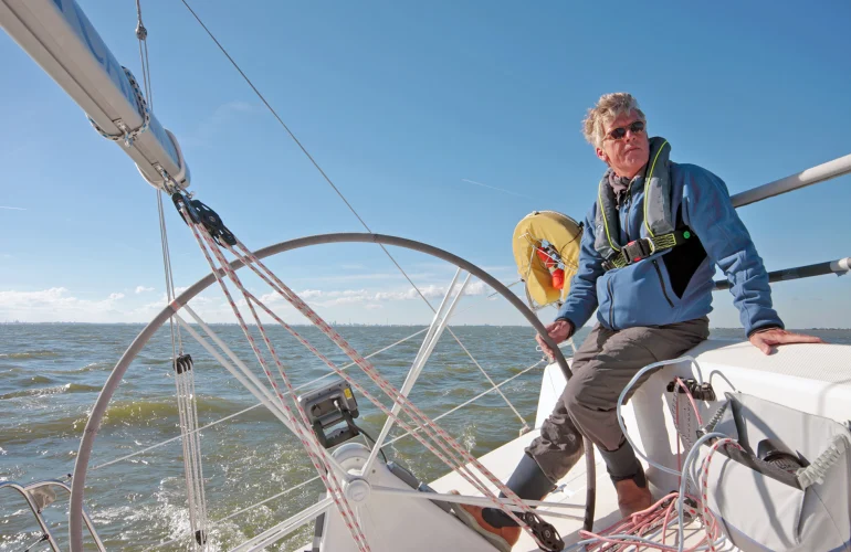 Man bestuurd een zeilboot