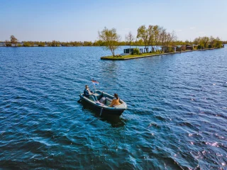Een sloep vaart bij een eiland