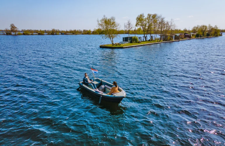 Een sloep vaart bij een eiland