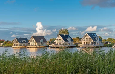 Vier huizen met puntdak op het water