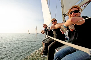 Zeilers op zeilboot genieten