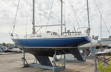 Zeilboot op een stalen bok op de kant in de haven