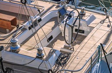 Kuip van een zeiljacht met teakdek, stuurwiel en lieren voor zeilbediening