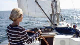 Vrouw achter het stuur op een boot